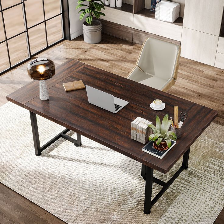 a wooden table with a laptop on top of it in a living room next to a potted plant