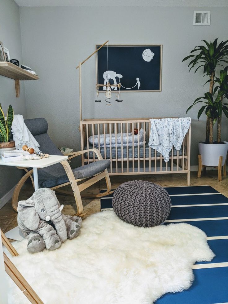 a baby's room with an elephant rug, rocking chair, and crib