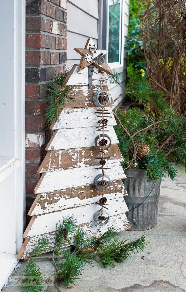 a small wooden christmas tree on the side of a house