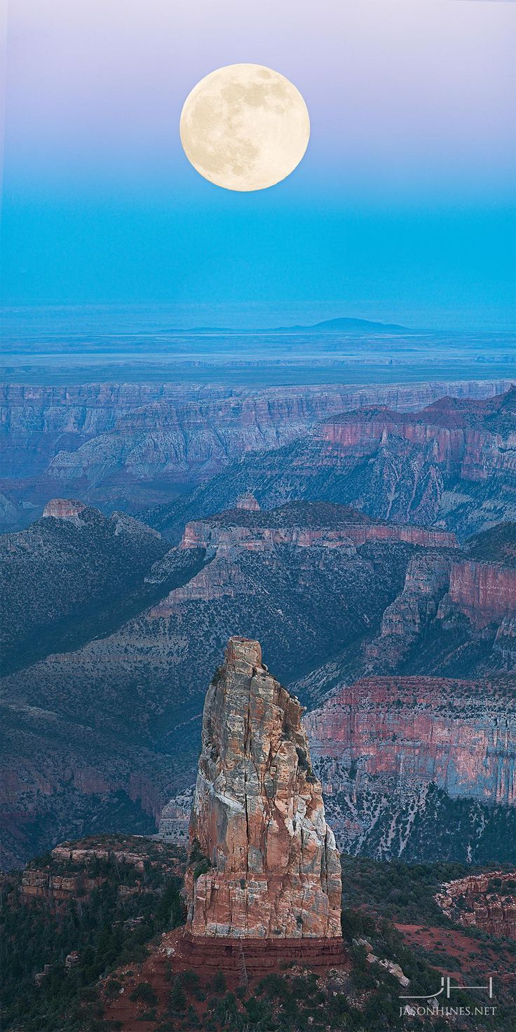 the full moon shines brightly in the sky above canyon