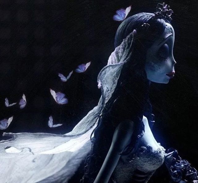 a woman in white dress with butterflies flying over her head and shoulders, looking at the ground