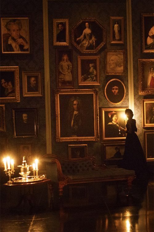 a person standing in front of pictures and candles