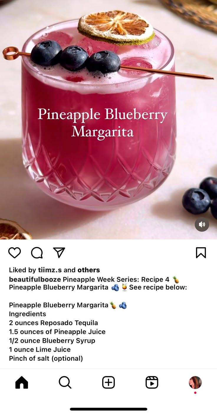 a pink drink with blueberries in it and the caption reads pineapple blueberry margarita