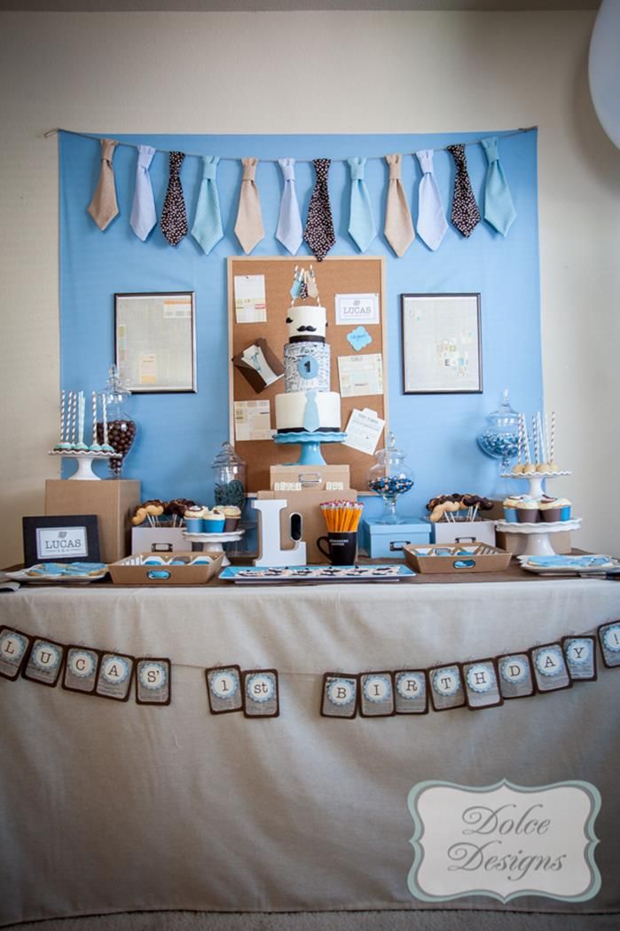 a table topped with lots of cake and cupcakes next to pictures on the wall