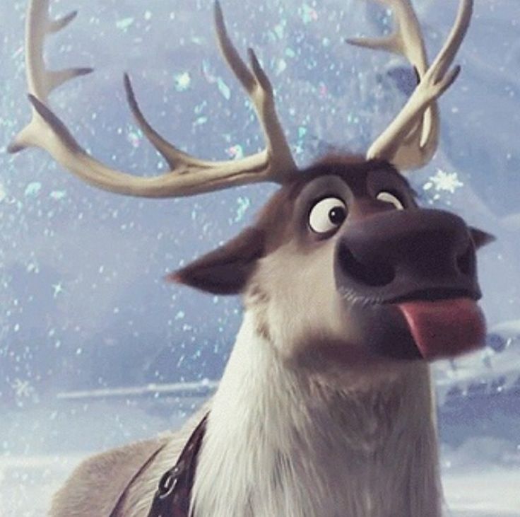 a reindeer with antlers on his head and tongue sticking out from behind it's back