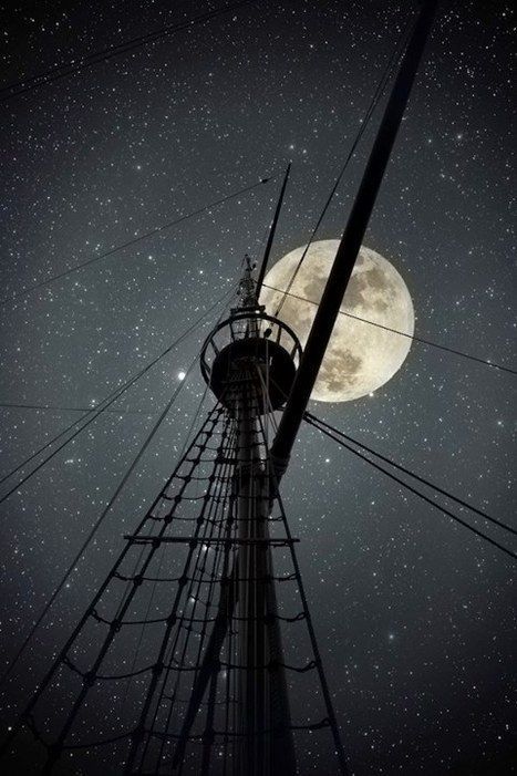 a tall tower with the moon in the sky above it and an inscription on top