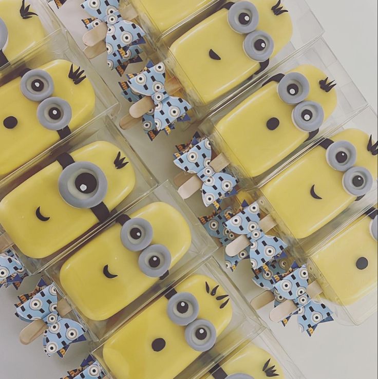 some yellow and blue cakes with eyes on them are arranged in a box together to look like they're ready for the party