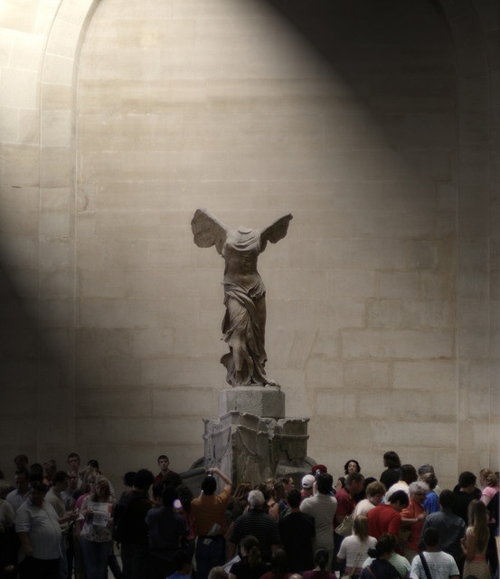 a crowd of people standing around a statue