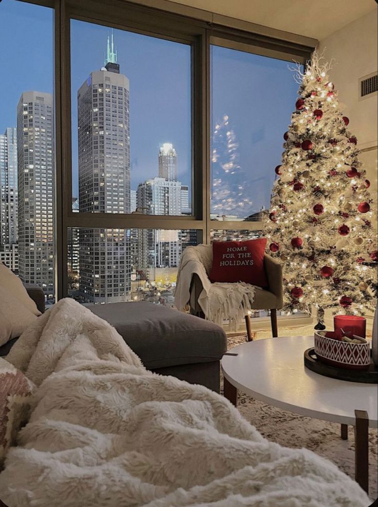 a living room filled with furniture and a christmas tree in front of a large window