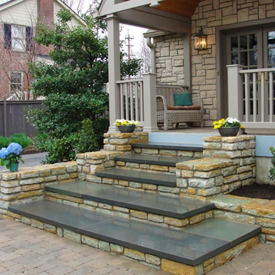 an outdoor patio with stone steps leading up to the front door