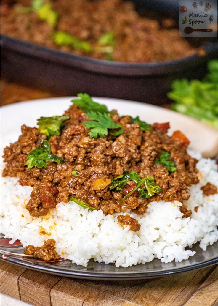 a close up of a plate of food with rice and ground beef on it next to other dishes