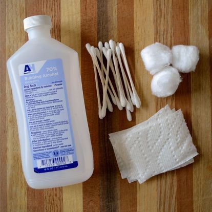 cotton swabs, toothpaste and other items are laid out on a wooden surface