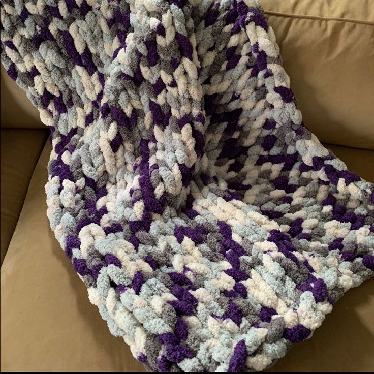 a crocheted blanket sitting on top of a couch