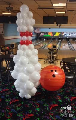 an inflatable bowling ball and balloon tree at a bowling alley