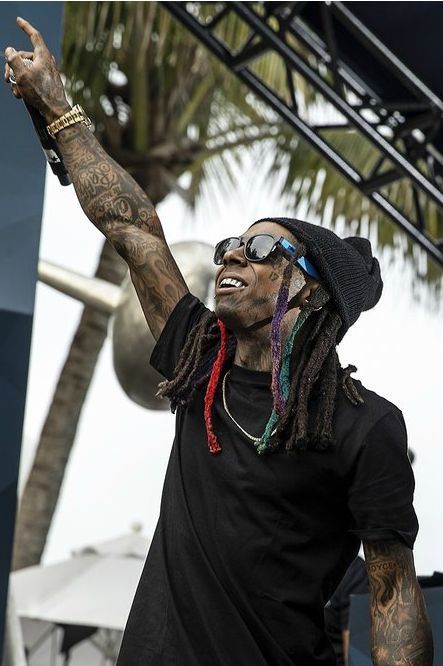 a man with dreadlocks on his head and sunglasses is standing in front of a stage