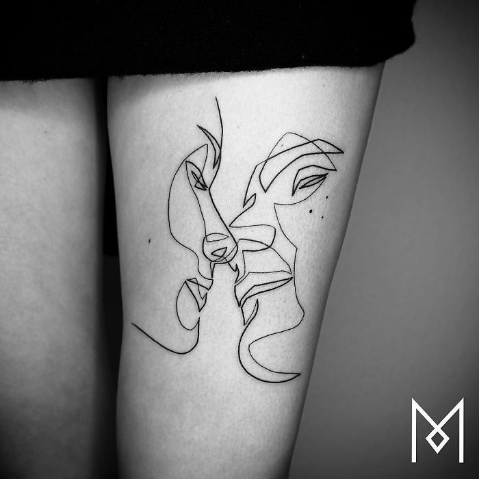 a black and white photo of a woman's leg with a tattoo on it