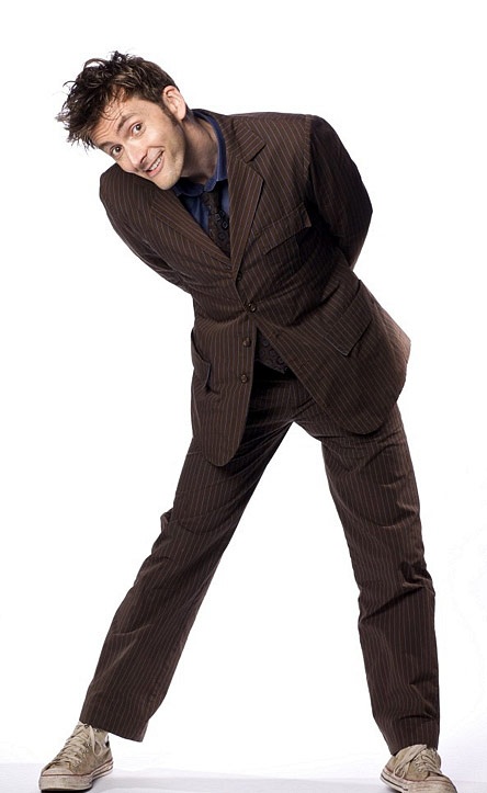 a man in a suit and tie posing for a picture with his hands on his hips