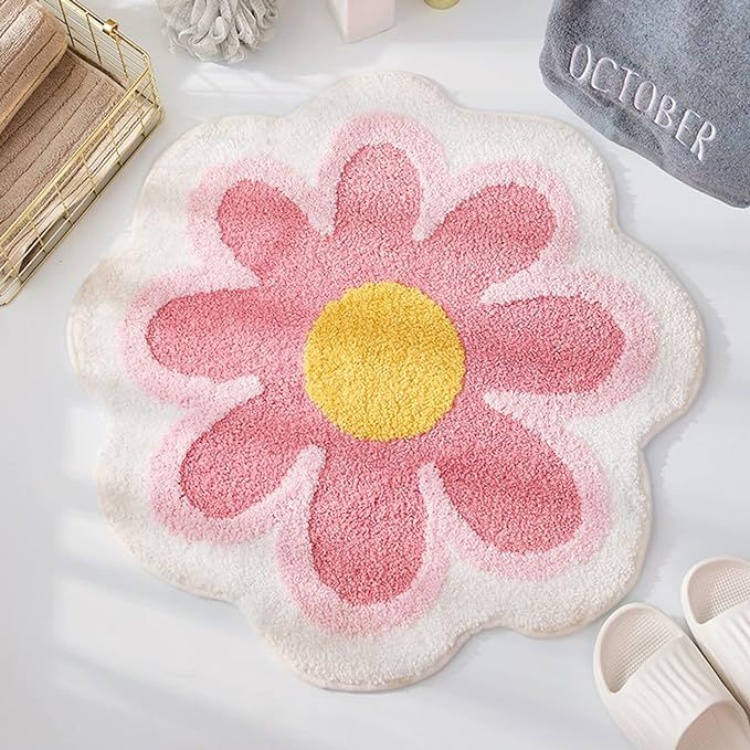 a pink and yellow flower rug sitting on top of a white table next to shoes