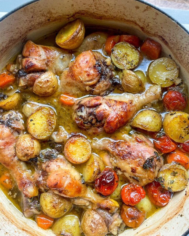 a pot filled with chicken and vegetables on top of a stove