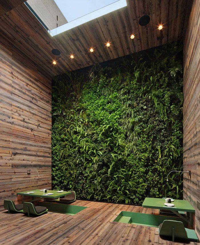 a room with wooden walls and green plants on the wall