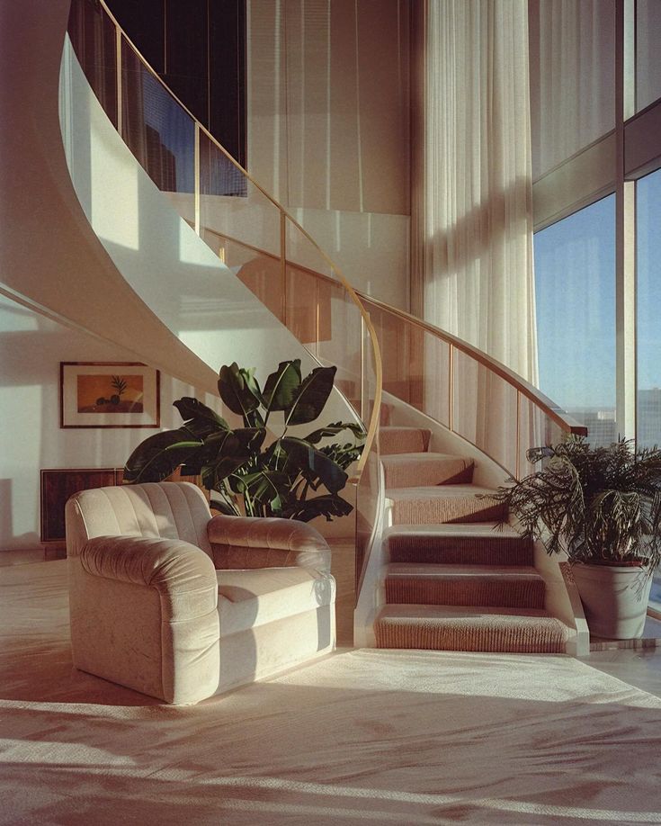 a living room filled with furniture and a spiral stair case next to a large window