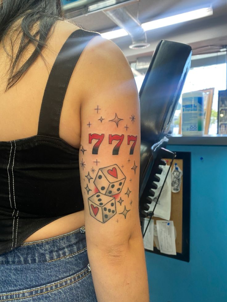 a woman with a tattoo on her arm that reads 777 and has dice in it