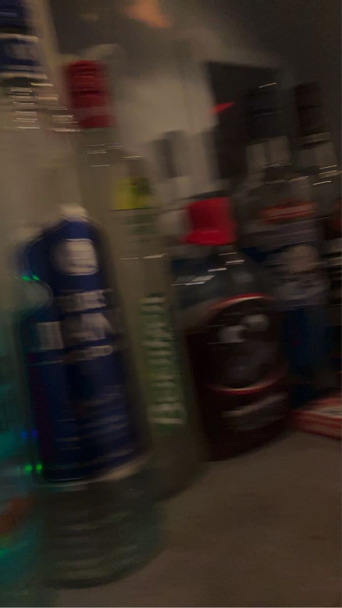 blurry photograph of various bottles on display in a store or office building, with one being blurred by the camera