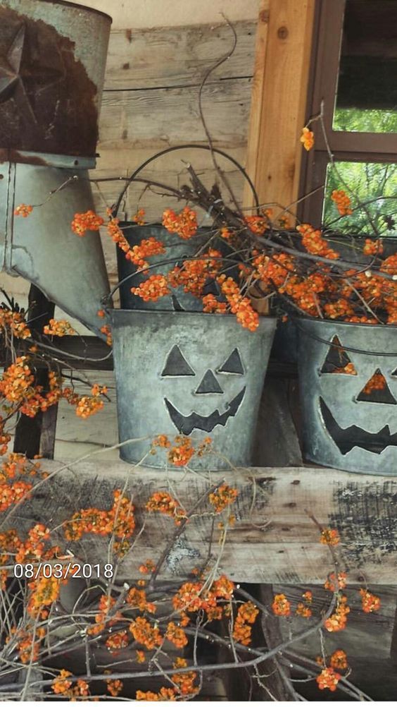 three buckets with pumpkin faces painted on them