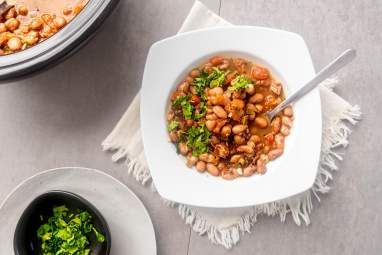 two white bowls filled with food on top of a table next to a bowl of broccoli