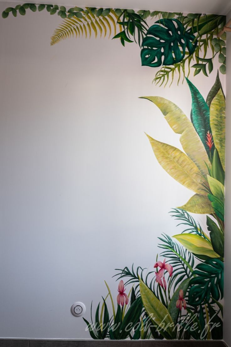 the wall is painted with tropical leaves and flowers