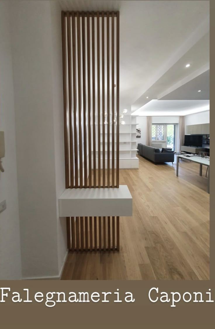 an empty living room with white walls and wooden slats on the wall, along with hardwood flooring