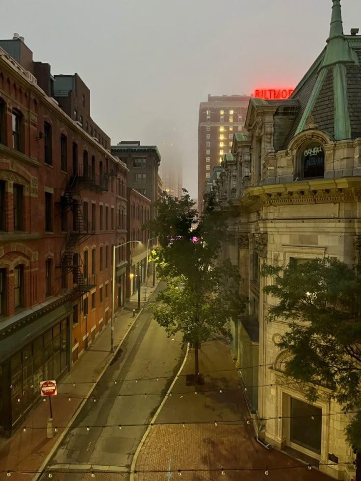 an empty city street at night with buildings in the background