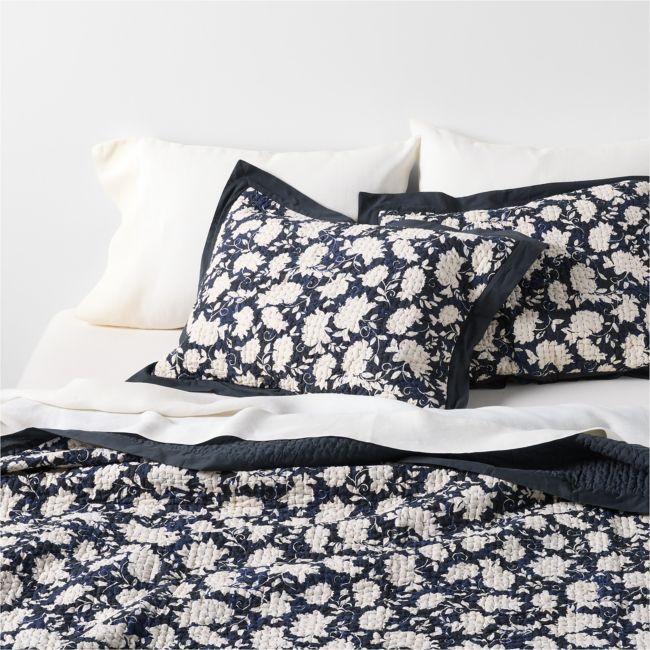 a bed with blue and white pillows on top of it