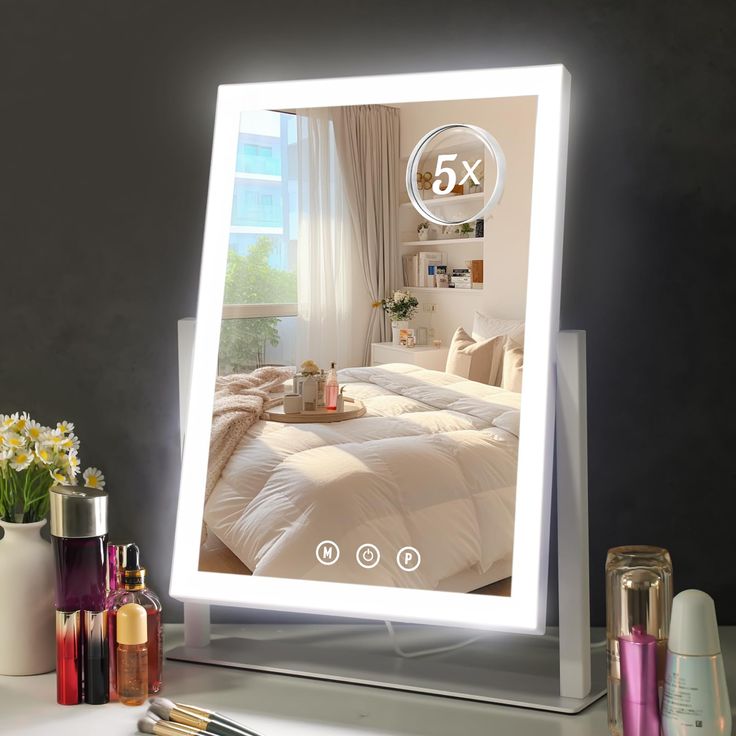 a lighted mirror with the image of a bed and flowers on it next to other items