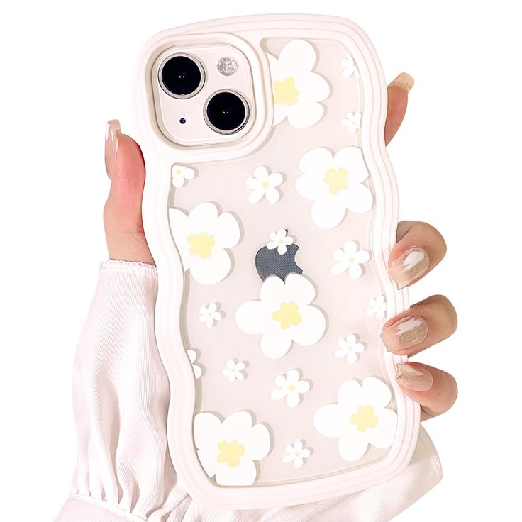 a woman holding up an iphone case with flowers on the front and back cover in her hand