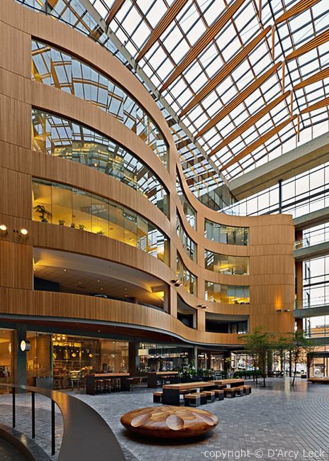 the inside of a large building with lots of glass and wood on it's walls