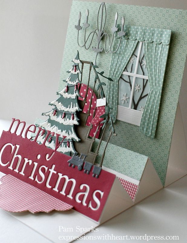 a christmas card with an ornament, tree and window on the front that says merry christmas