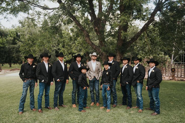 a group of men standing next to each other in front of a tree