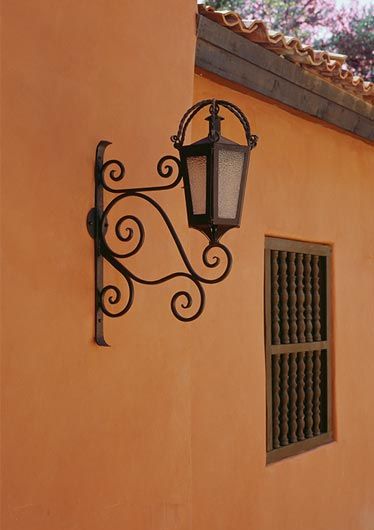 an old fashioned street light on the side of a building