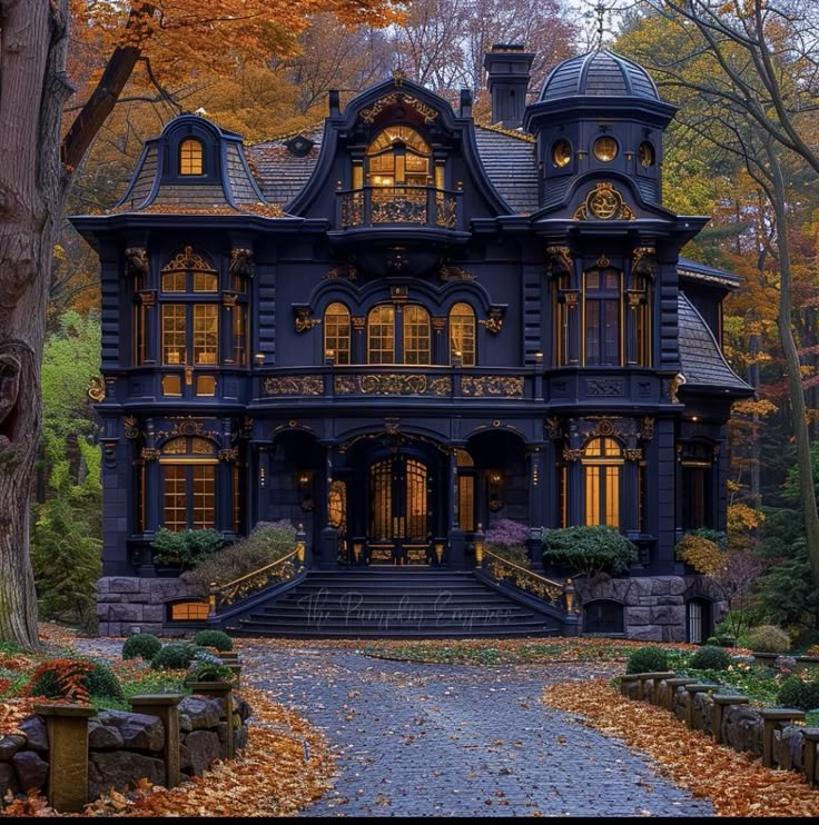 an old victorian style house is lit up in the fall colors with leaves on the ground