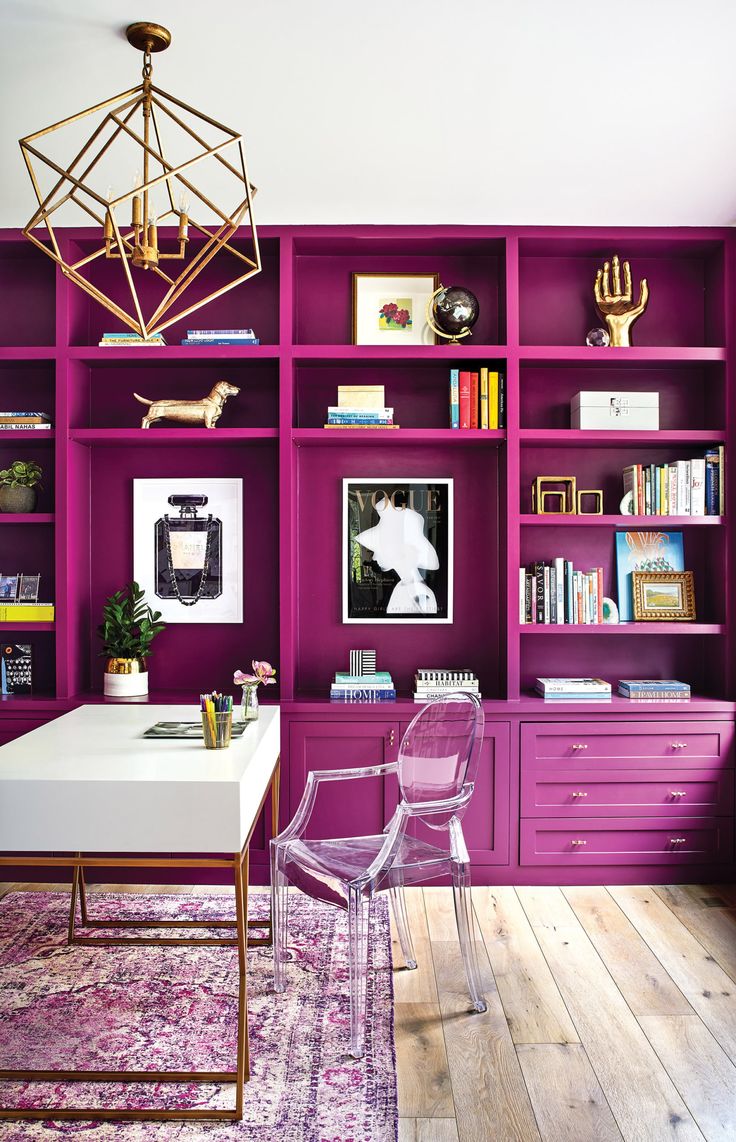 an office with purple shelving and pink chairs in front of a white desk on top of a wooden floor