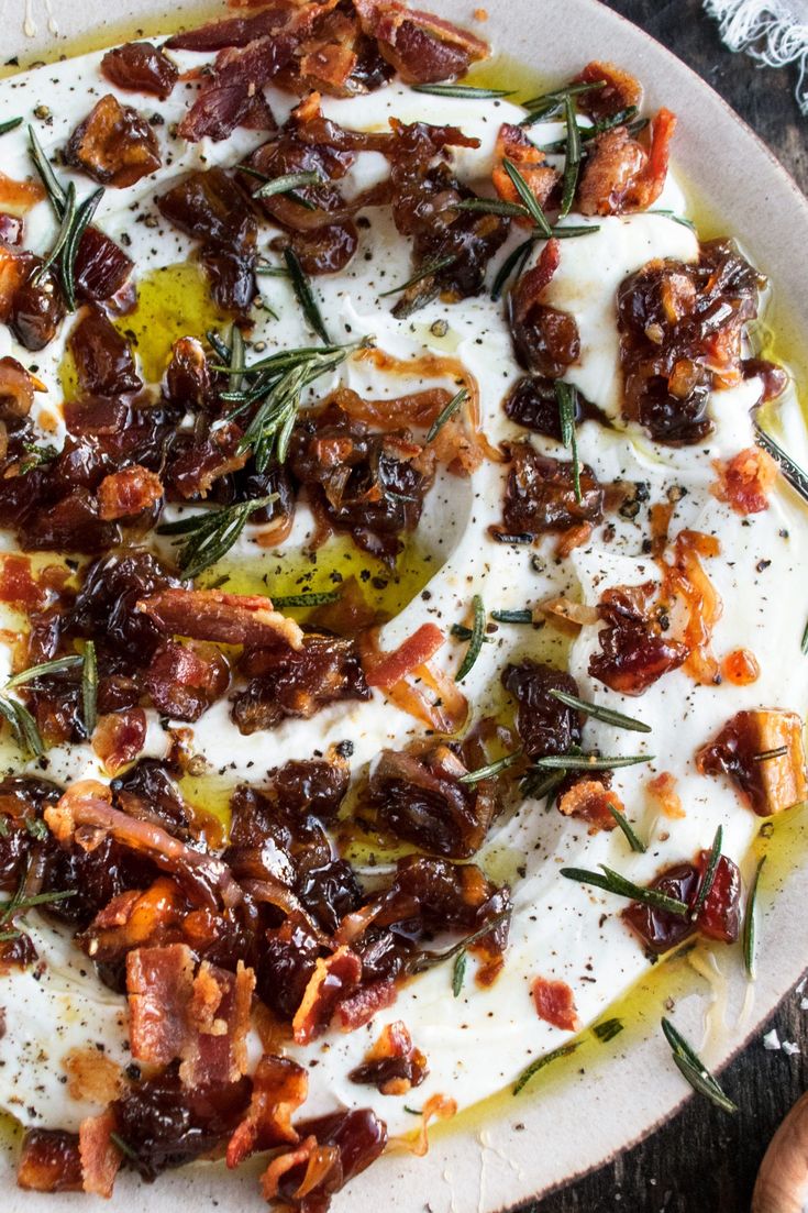 a white plate topped with lots of food on top of a wooden table next to utensils