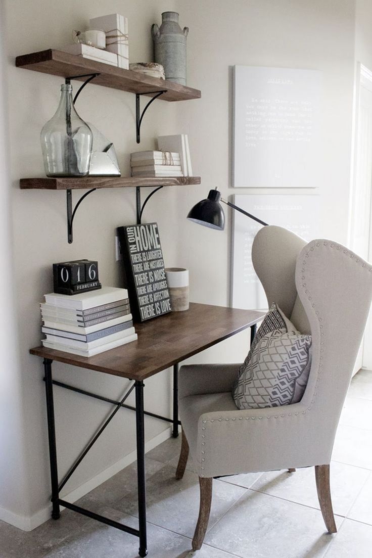 a chair sitting in front of a desk with books on it and a lamp next to it