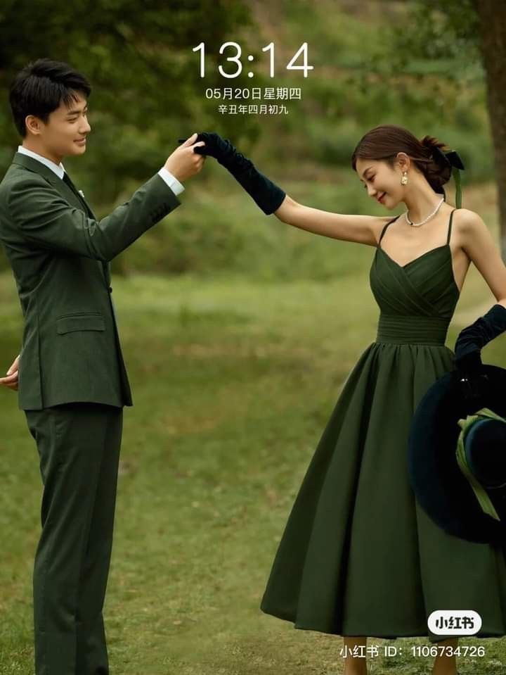 a man in a suit and tie holding the hand of a woman in a green dress