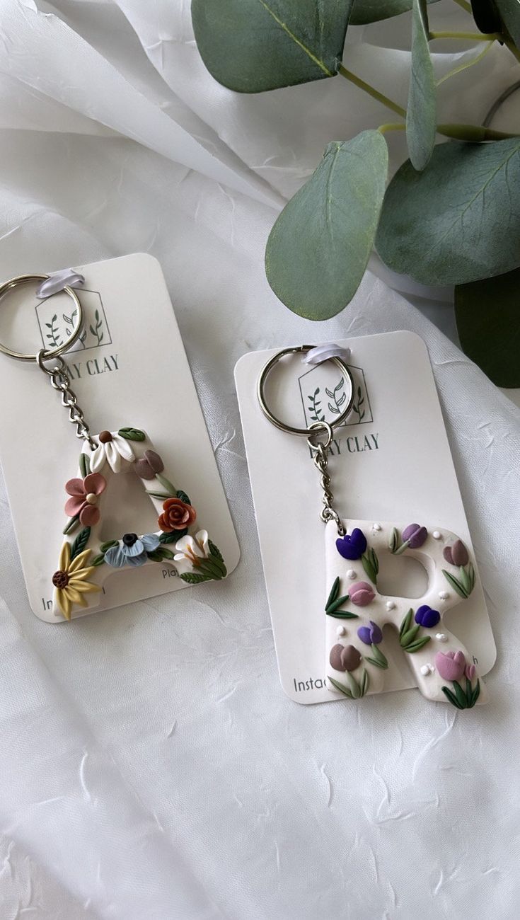 two key chains with flowers on them sitting next to each other