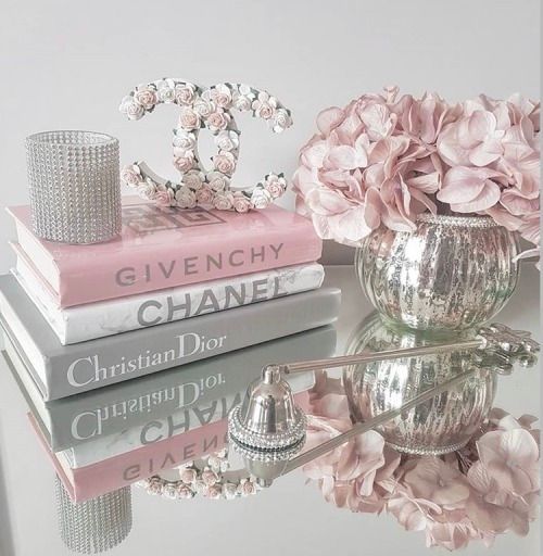 a stack of books sitting on top of a table next to a vase filled with flowers