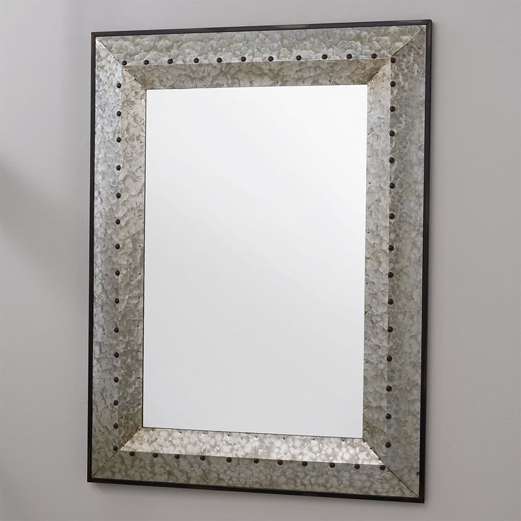 a mirror hanging on the wall with dots around it's edges and an edge