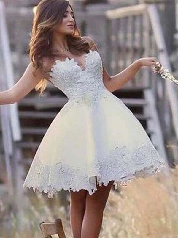 a woman in a short white dress standing on a wooden bench with her arms outstretched