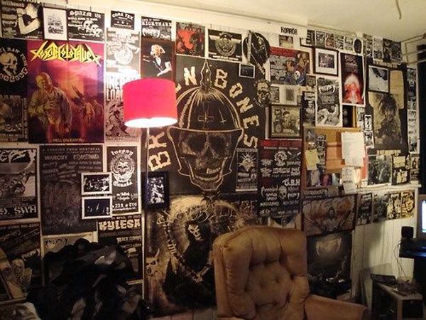 a living room filled with lots of posters on the wall and a chair in front of it