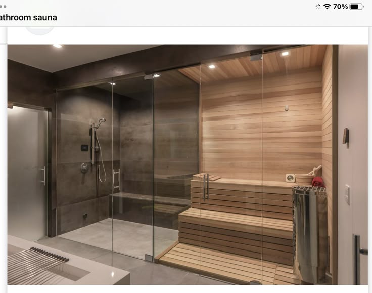 a wooden sauna in a bathroom with glass walls and flooring, along with a walk - in shower